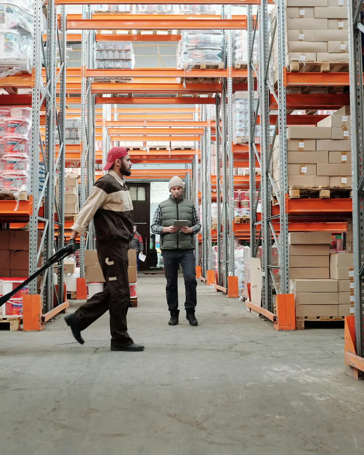 Warehouse team moving stock through a racked aisle